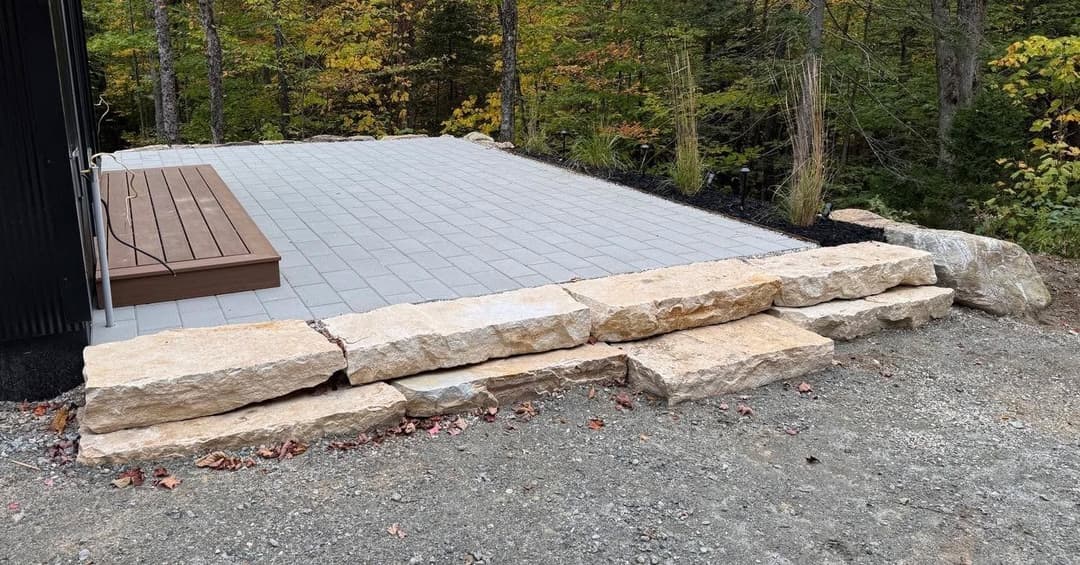 Paved patio with natural stone steps, surrounded by trees and autumn foliage.